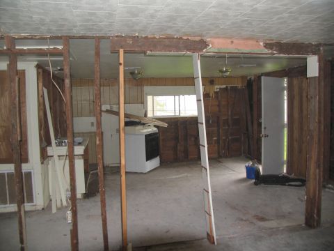 1995 Ford C-350 (Centurion Conversions) - The interior of a room shows significant damage with exposed studs and debris, indicating a need for renovation.