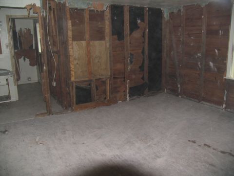 1995 Ford C-350 (Centurion Conversions) - The interior of a room shows significant damage to the walls and floor, indicating a need for renovation.