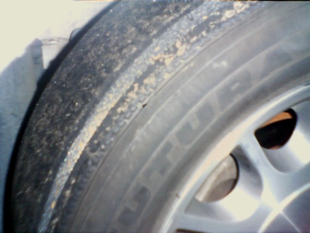 Close-up of a dirty tire and silver alloy wheel on a car