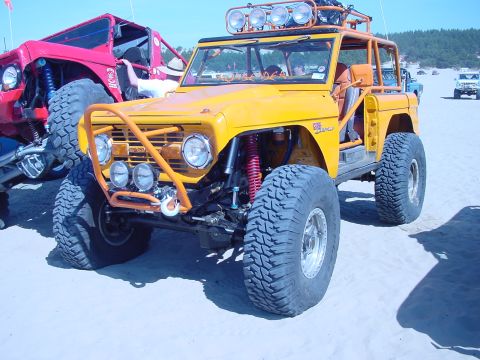 1979 Ford Bronco - Modified 1979 Ford Bronco with large tires and off-road modifications parked on a sandy beach.