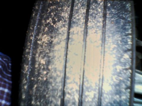 1998 Ford Taurus - The tire tread is caked with dried mud, obscuring the details of the tire pattern.