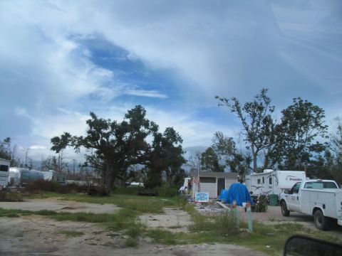 1995 Ford C-350 (Centurion Conversions) - A white pickup truck is parked in a scene with RVs and a small building, possibly a temporary shelter.