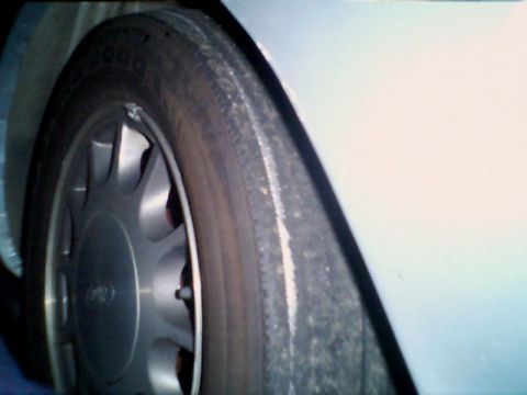 1998 Ford Taurus - Close-up of a 1998 Ford Taurus wheel and tire.