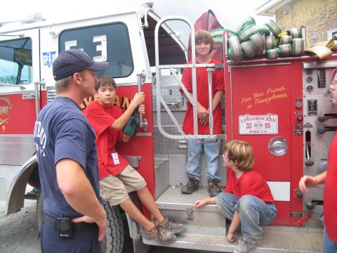 1995 Ford C-350 (Centurion Conversions) - Children interact with a fire truck, which has a license plate indicating "35 95 FIRE CO."