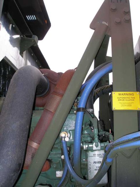 1998 Ford Crown Victoria - Green Detroit Diesel engine installed in an olive-drab military vehicle chassis, with a large black air intake hose, a corrugated red-oxide…
