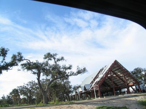 1995 Ford C-350 (Centurion Conversions) - A building shows significant damage to its roof and structure, likely from a storm.