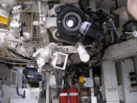 1998 Ford Crown Victoria - Cramped interior of an armored military vehicle showing turret optics, hydraulic lines, fire extinguishers and equipment.