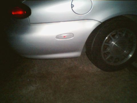 1998 Ford Taurus - Rear view of a silver sedan, showing the quarter panel, taillight, and wheel.
