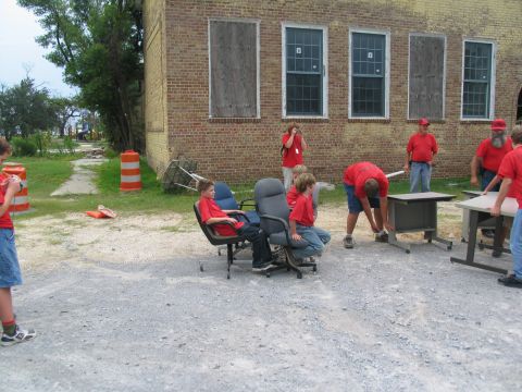 1995 Ford C-350 (Centurion Conversions) - Volunteers move office furniture outside a damaged brick building after a disaster.