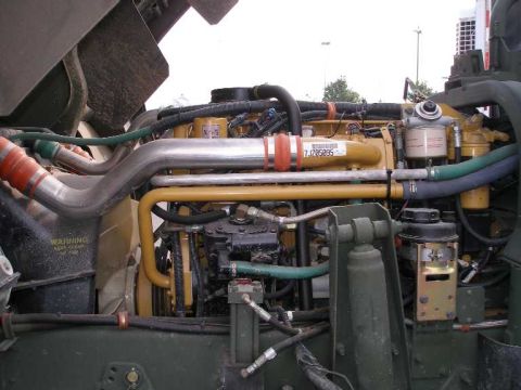 1998 Ford Crown Victoria - Open engine bay of a military-green heavy truck showing a yellow Caterpillar diesel with polished intercooler piping clamped in orange coup…