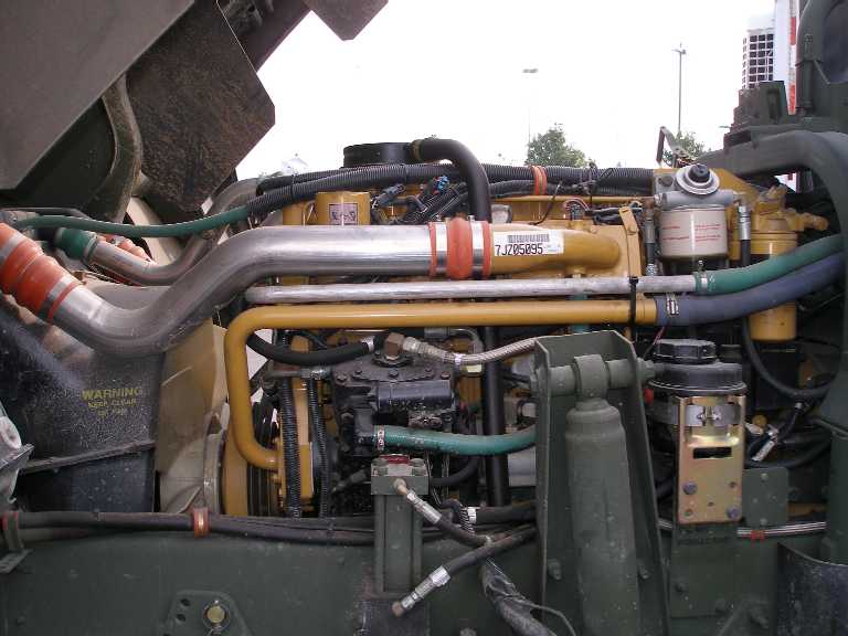 Yellow Caterpillar diesel engine in the olive-green bay of a military cargo truck