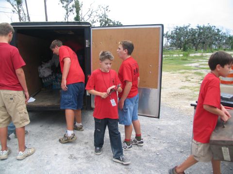 1995 Ford C-350 (Centurion Conversions) - Boys are seen unloading supplies from a trailer, possibly for disaster relief efforts.