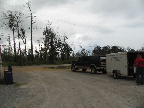 1995 Ford C-350 (Centurion Conversions) - A dark Ford Bronco tows a trailer, possibly for disaster relief, under a cloudy sky.