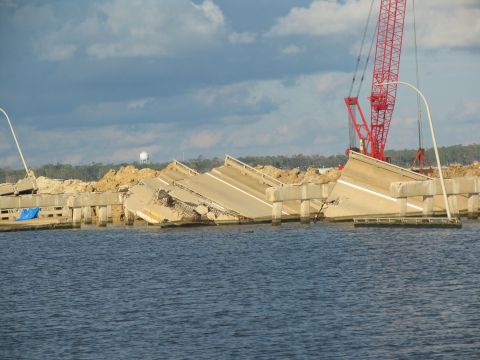 1995 Ford C-350 (Centurion Conversions) - A collapsed bridge section is visible over the water, with a large red crane nearby.