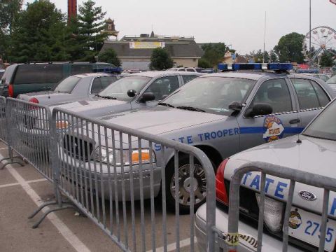 1998 Ford Crown Victoria - A row of gray Kentucky State Police Ford Crown Victoria cruisers with STATE TROOPER hood lettering and door shields parked behind steel cro…
