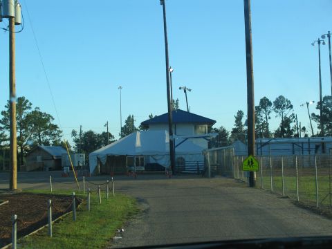 1995 Ford C-350 (Centurion Conversions) - A large tent and building are set up at an outdoor location, possibly for an event or relief effort.