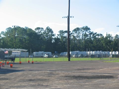 1995 Ford C-350 (Centurion Conversions) - Multiple RV trailers are parked in a field, with a sign indicating 'Camp New Hope'.