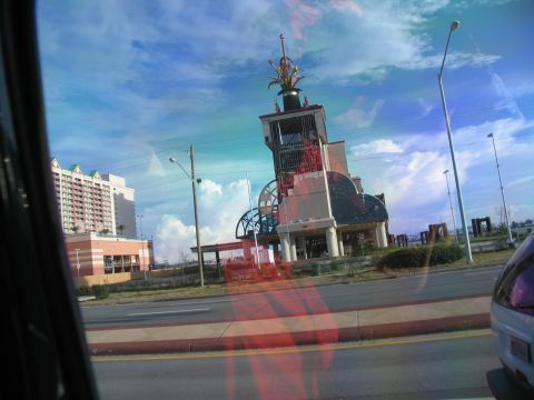 1995 Ford C-350 (Centurion Conversions) - View of a unique building and a hotel from a vehicle, with reflections on the window.