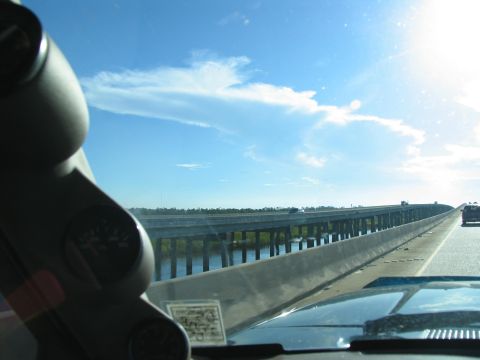 1995 Ford C-350 (Centurion Conversions) - View from a vehicle driving across a bridge, with dashboard gauges visible in the foreground.