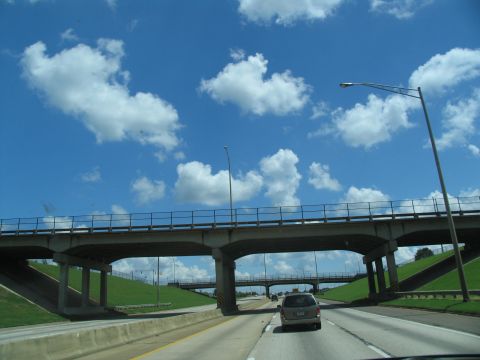1995 Ford C-350 (Centurion Conversions) - Driving on a highway under a concrete overpass on a partly cloudy day.