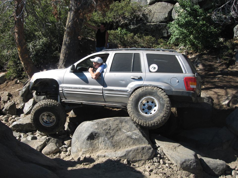 Silver 1999 Jeep Grand Cherokee side view, navigating rocky terrain