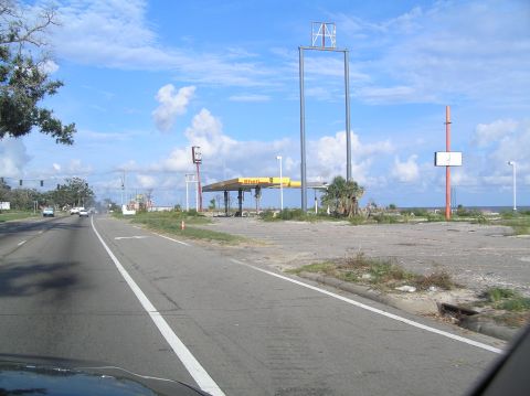 1995 Ford C-350 (Centurion Conversions) - Roadside view of an abandoned Shell gas station, likely damaged by a storm.