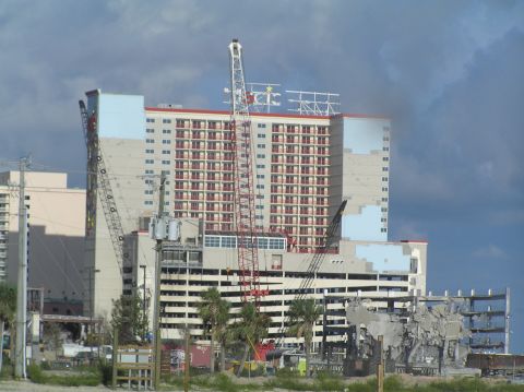 1995 Ford C-350 (Centurion Conversions) - Cranes are active at a construction site with buildings in various stages of demolition and completion.