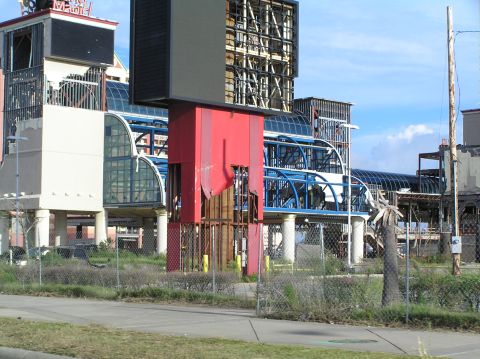 1995 Ford C-350 (Centurion Conversions) - A scene of destruction shows a damaged building with exposed structural elements and torn siding, under a partly cloudy sky.