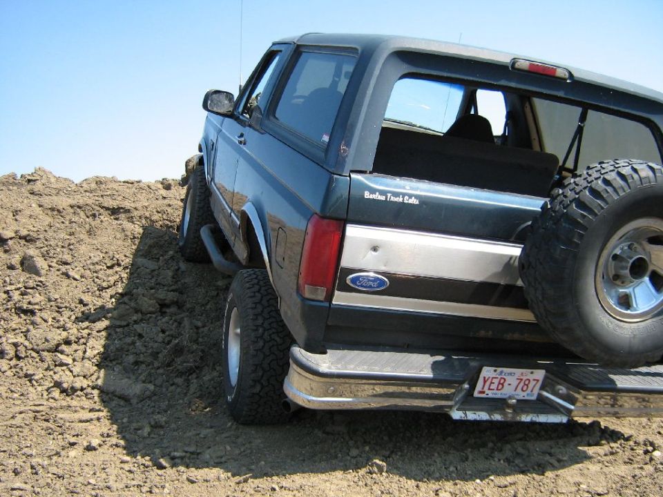 1995 Ford Bronco on a dirt mound, rear view, spare tire mounted on back