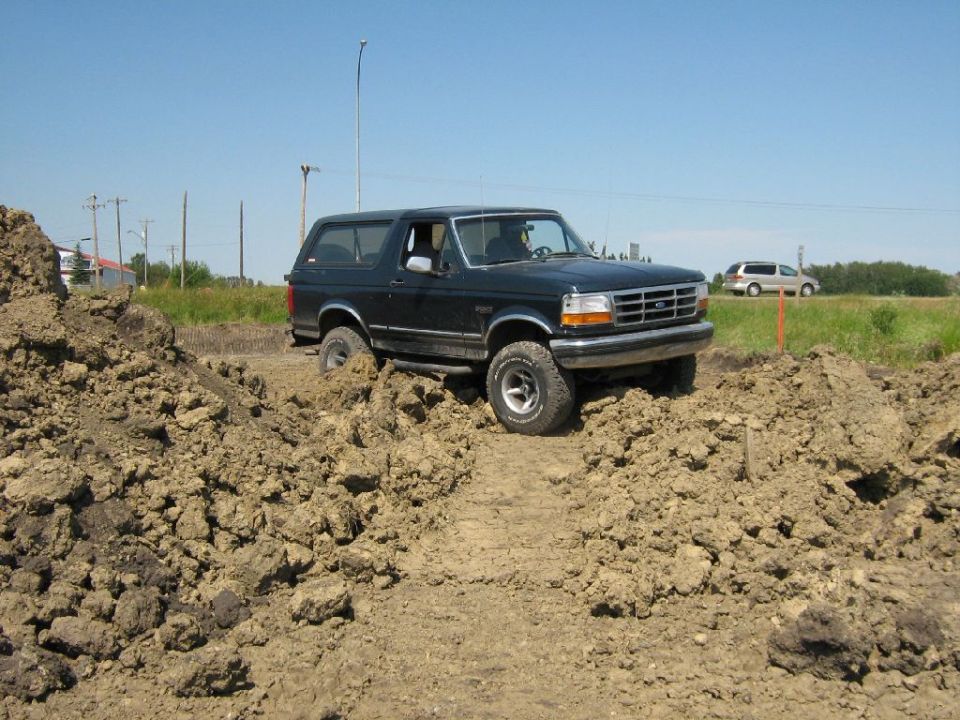 Black 1995 Ford Bronco navigating a dirt track