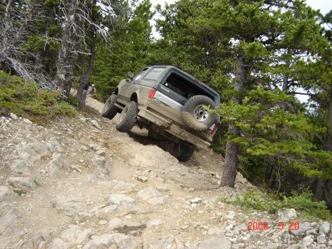1995 Ford Bronco - This 1995 Ford Bronco navigates a challenging off-road path through a wooded mountainside.