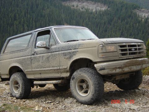 1995 Ford Bronco - This 1995 Ford Bronco is shown on a , rocky terrain with a dense forest behind it.