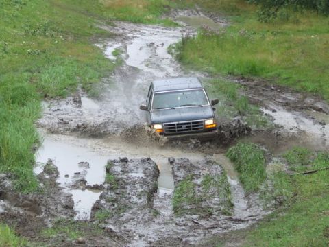 1995 Ford Bronco - Ford Bronco tackles a challenging muddy obstacle course.