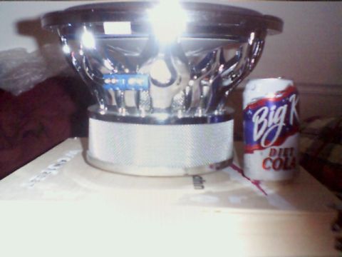 1998 Ford Taurus - A car subwoofer with chrome accents sits beside a can of Big K Diet Cola.