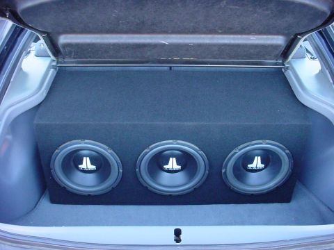 1994 Ford Probe - Custom subwoofer enclosure with three JL Audio speakers installed in the trunk of a vehicle.