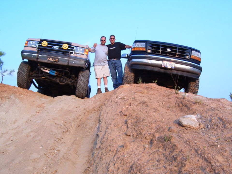 1993 Ford Bronco and another Ford truck on a dirt hill
