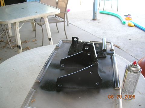 1985 Ford Bronco - Metal brackets freshly painted black sit on a tray next to a can of spray paint.