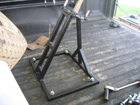 1999 Toyota Tacoma - A tire jack is stored in the bed of a truck, alongside a spare tire and tools.