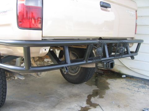 1999 Toyota Tacoma - Rear view of a tan truck with a heavy-duty aftermarket bumper and tow hitch installed.