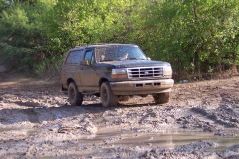 1996 Ford Bronco - 1996 Ford Bronco navigating a challenging muddy off-road course.