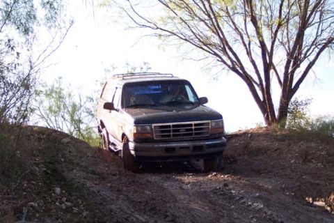 1996 Ford Bronco - 1996 Ford Bronco navigating a steep dirt path during an off-road excursion.