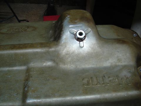 1996 Ford Bronco - Close-up of a Ford oil pan, showing the brand emblem and a drain plug assembly.