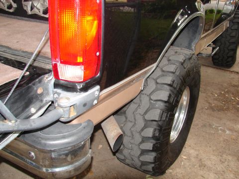 1996 Ford Bronco - Rear view of a black Ford Bronco showing its off-road tire and chrome trim details.