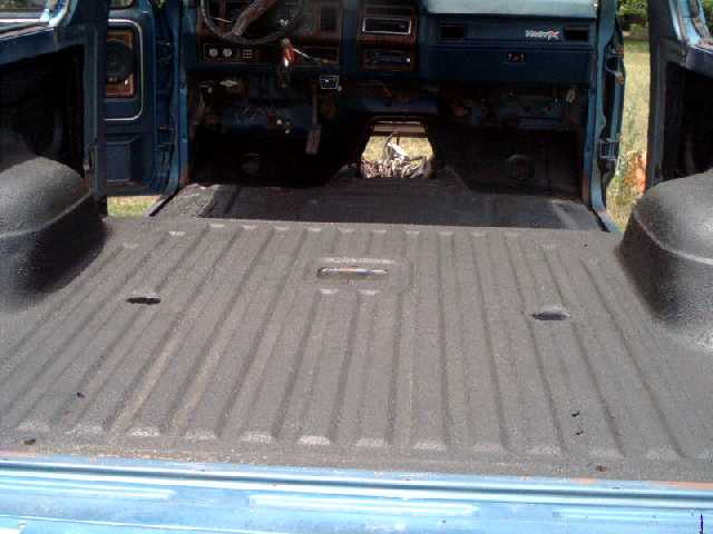 Bronco rear cargo floor with gray textured bedliner coating, blue dash ahead