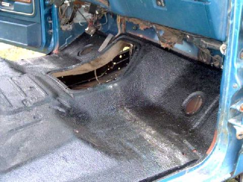1984 Ford Bronco - The interior floor of a blue vehicle shows a black spray-on bedliner application.