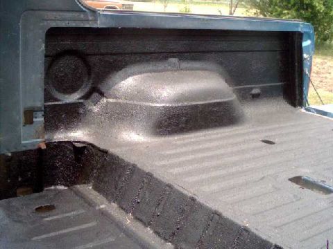 1984 Ford Bronco - Newly applied spray-on liner in a truck bed, covering the wheel well and floor.