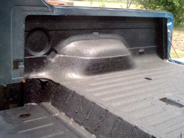 Black textured spray-on bedliner over bed and wheel well, blue body panels