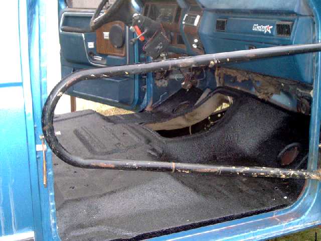 Blue Ford interior with black roll bar and bedliner-coated floor