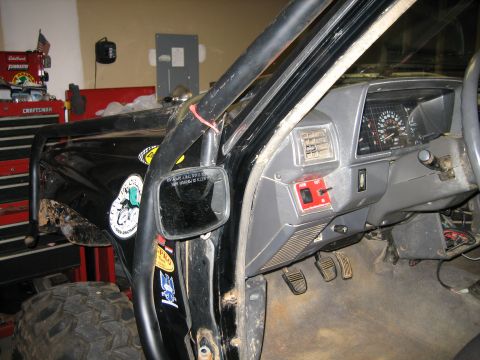 1986 Ford F-150 - Interior of a modified truck, showing the dashboard, pedals, and roll cage structure.