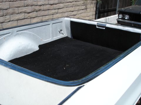 1973 Ford Ranchero - The bed of a 1973 Ford Ranchero shows black matting and a glimpse of another vehicle behind it.